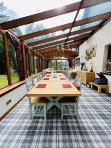 uma grande sala de jantar com mesa e cadeiras em Tarmachan Cottage - West Highland Getaway em Fort William