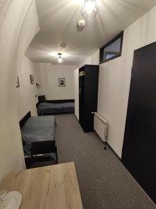 Zimmer mit einem Tisch, einem Sofa und einem Bett in der Unterkunft Twierdza Toruń - Fort IV in Toruń