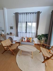 ein Wohnzimmer mit einem Sofa, Stühlen und einem Tisch in der Unterkunft Sleep private khaoyai in Mu Si