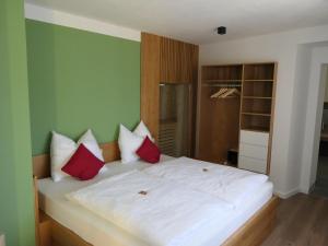 1 dormitorio con 1 cama con almohadas rojas y blancas en Fewo Blick zum Stern, en Wermsdorf