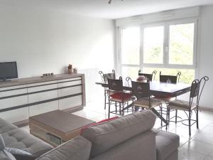 a living room with a couch and a table with chairs at Chambre #2 dans appartement partagé - Proche des Vosges in Thann