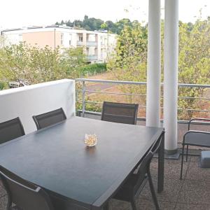 einen schwarzen Tisch und Stühle auf dem Balkon in der Unterkunft Chambre #2 dans appartement partagé - Proche des Vosges in Thann