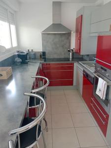 - une cuisine avec des placards rouges et une cuisinière dans l'établissement Chambre #2 dans appartement partagé - Proche des Vosges, à Thann