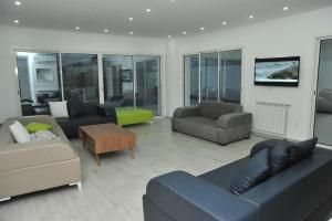 a living room with couches and chairs and a tv at SOUSSE BEACH in Hammam Sousse