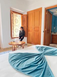 a woman sitting at a table in a bedroom at Palais Nejma oriental in Marrakesh