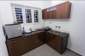 a small kitchen with a sink and a refrigerator at Salamath Homestay in Cochin