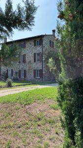 an old stone building with trees in front of it at Cà Vittoria in Desenzano del Garda