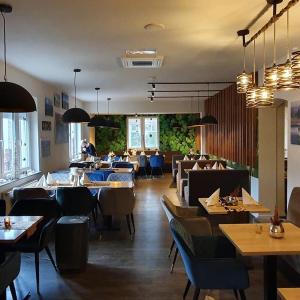 ein Restaurant mit Tischen und Stühlen und ein Esszimmer in der Unterkunft Rhönblick Landhotel - Restaurant - Countrypub in Petersberg