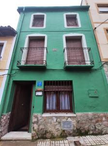 zielony budynek z dwoma oknami i drzwiami w obiekcie My Love w mieście Arenas de San Pedro