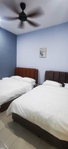 a bedroom with two beds and a ceiling fan at Bahagia 137 Homestay with private pool in Port Dickson