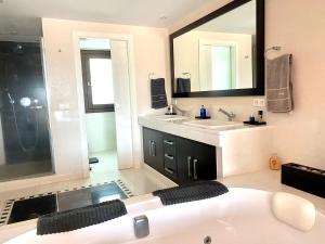a bathroom with a large white tub and a sink at Luxury Villa with Pool in Marbella