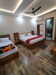 a bedroom with two beds and a ceiling fan at Hotel Taj Sarovar By WB Inn in Agra