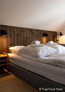 a large bed with two white pillows on it at Fugl Fønix Hotel in Etnesjøen
