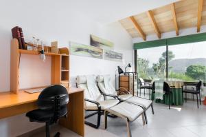 een salon met stoelen, een bureau en een tafel bij YourHouse Binifat in Andratx