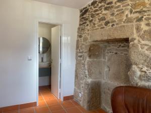GondarémにあるCasas da Loureira - Casa do Agostinhoのバスルーム付きの客室で、石造りの暖炉が備わります。