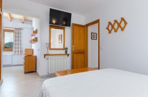 1 dormitorio con 1 cama y TV en la pared en YourHouse Binifat, en Andratx