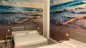 ボローニャにあるHotel Giardinetto Al Sant'Orsolaの海の絵画が飾られたベッドルーム