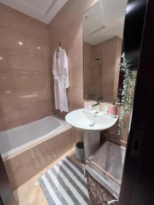 a bathroom with a sink and a bath tub at Sea La View Family Home in Ras al Khaimah