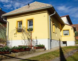 una casa amarilla y blanca con en Žltý domček - Apartmán Švábovce, en Svabovice