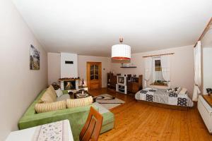een woonkamer met een groene bank en een bed bij Žltý domček - Apartmán Švábovce in Svabovice +6 foto's