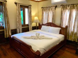 a bedroom with a bed with a bow on it at Siridel Luang Prabang in Luang Prabang +36 photos