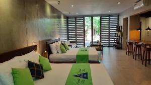 a bedroom with two beds with green pillows at Nirmala Villa in Habaraduwa Central