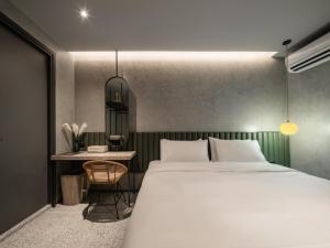 um quarto com uma cama grande e uma mesa em Goose Living em Bangkok
