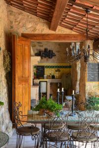 a dining room with a table and chairs and a kitchen at La Maison de Platane B&B in Fayence