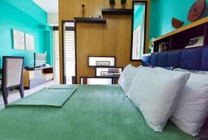 a bedroom with a green bed with white pillows at Miranda 504B 1BR at Pico de Loro by Raquel's Place in Nasugbu