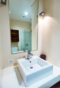 a bathroom with a white sink and a mirror at Miranda 504B 1BR at Pico de Loro by Raquel's Place in Nasugbu