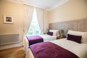 a bedroom with two beds and a window at Bishop's Gate Hotel in Derry Londonderry