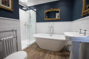 a bathroom with a tub and a sink and a toilet at Bishop's Gate Hotel in Derry Londonderry