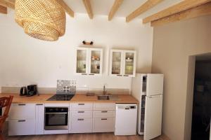 a kitchen with white cabinets and a white refrigerator at PETIT TERME - Piscine - CLIM - Parking in Les Angles Gard