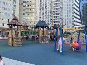 a playground in a city with people playing on it at Roini Apartment in Batumi