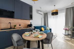 a kitchen and living room with a table and chairs at Niedziałkowskiego 25 Apartments Stary Browar City Center by Renters Prestige in Poznań