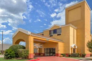 a large yellow building with an arch entrance at Quality Inn Baytown - Houston East in Baytown