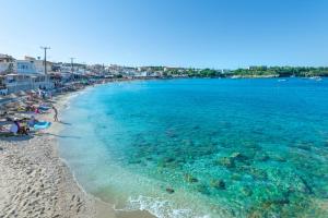 a view of a beach with people and the ocean at MK Summer Breeze Luxury Apartments in Agia Pelagia