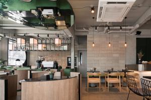 a restaurant with tables and chairs in a room at Goose Living Bangkok BTS Phra Khanong in Bangkok