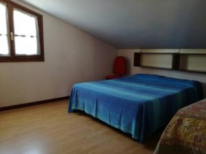 1 dormitorio con 1 cama azul y 1 silla roja en attico panoramico sul mare, en Santa Maria Navarrese