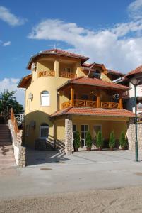 una grande casa gialla con balcone in cima di Vila Simic Srebrno Jezero a Ostrovo