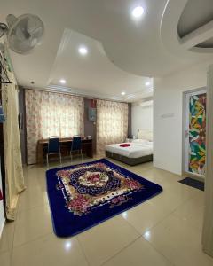 a bedroom with a bed and a blue rug on the floor at D' Anjung Inn in Tangkak