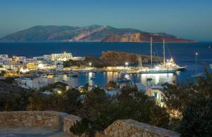 a view of a harbor at night with a boat in the water at Sirokos in Karavostasi