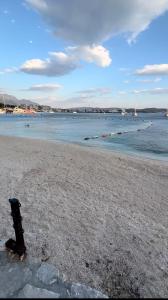 a black fire hydrant sitting on a beach near the water at Apartments Tivat in Tivat