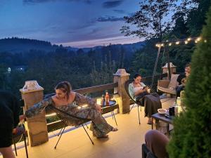 a group of people sitting on a deck at night at VILA GIGI, ideala pentru relaxare si distractie! in Breaza