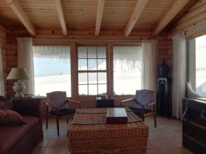 - un salon avec une table, des chaises et des fenêtres dans l'établissement Chalet de Charme, Cedar, Lebanon, ENTIRE CHALET, à Arz