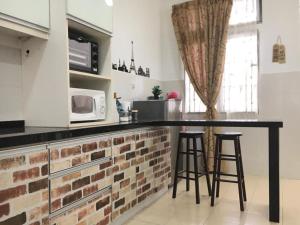 a kitchen with a counter with stools and a microwave at KUL Rest House in Labu