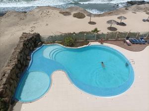 una vista aérea de una piscina junto a la playa en Seafront Holiday House on the Mindelo Bay, en Mindelo