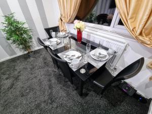 a black table with black chairs and plates on it at *10OR* Setup for your most relaxed & amazing stay + Free Parking + Free Fast WiFi * in Leeds