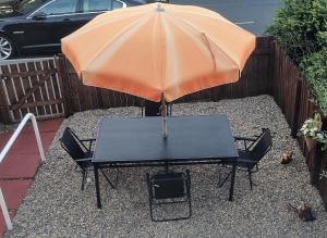 a table with an orange umbrella and a table with chairs at *10OR* Setup for your most relaxed & amazing stay + Free Parking + Free Fast WiFi * in Leeds