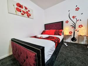 a bedroom with a bed with a red and black bedspread at *10OR* Setup for your most relaxed & amazing stay + Free Parking + Free Fast WiFi * in Leeds